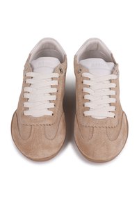 Beige mokkasiner i semsket skinn med hvite snørebånd, rund tå og subtile sømdetaljer. Glatt innerfôr og minimalistiske designelementer.