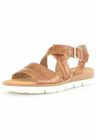 Brun lædersandal med krydsede remme og en sidebuckle. Har en polstret indersål og en hvid gummisål med skridsikre detaljer.