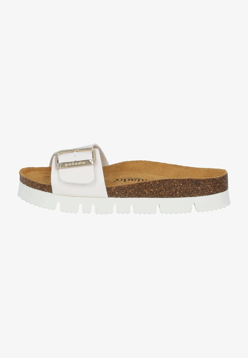 White slide sandal with a textured cork footbed, a thick white rubber sole, and a wide strap featuring a metal buckle detail.