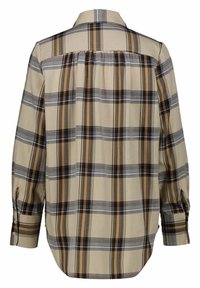 Camicia a quadri con maniche lunghe, nei colori beige, marrone, grigio e nero. Polsini abbottonati e dettaglio in yoke sul retro. Tessuto leggero.