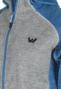 Hoodiejacka i grått, texturerat tyg med blå accenter. Har en dragkedja framtill och en liten logotyp. Geometriskt mönster på den grå delen.