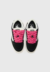 Black suede sneakers with vibrant pink laces and white accents. Features a cushioned collar and flat rubber sole. Branding visible on the tongue.