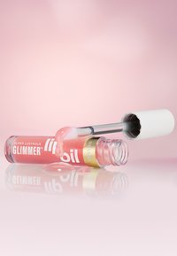 Tubetto di olio labbra in vetro trasparente con una fascia dorata, contenente un liquido rosa e un tappo bianco, con olio che gocciola dall'applicatore.