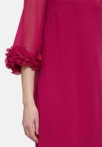 Fuchsia Kleid mit durchsichtigen Ärmeln und gerüschten, plissierten Manschetten. Glatte Textur, knielanges Design. Zeitgenössische Silhouette.