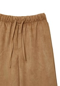 Helle Wildleder-Jogginghosen mit elastischem Bund und Kordelzug. Weicher Stoff mit glatter Oberfläche und seitlicher Nahtdetail.