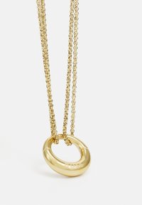 Collana in tonalità oro con un pendente circolare liscio con il nome del marchio inciso, sospesa a due fili di catena fine.