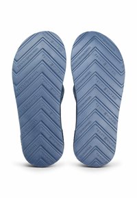 Blå gummisandalsåler med et zigzag mønster. Har præget branding, der giver greb og holdbarhed.