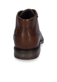 Bottine en cuir brun avec un bout arrondi, des détails de couture subtils et un talon empilé. L'intérieur présente une doublure contrastante noire.