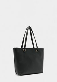 Czarna torba typu tote z eko skóry z dwoma długimi uchwytami, o prostokątnym kształcie, gładkiej teksturze i minimalistycznym designie. Ozdobiona złotymi elementami metalowymi.