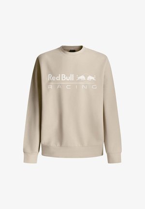 Beige spordipusa, millel on ümar kaelus ja ees on valge "Red Bull Racing" logo, ning ribatooted varrukaotsades ja allääres.