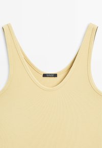 Ribbet gul tanktop med brede stropper og rund halsudskæring. Har en syet kant og et mærke med teksten "Massimo Dutti."