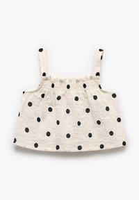 Hvid cropped top med sorte prikker, som har justerbare stropper og rynket elastik ved halsen, lavet af tekstureret stof.