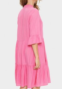 Rosa knieumspielendes Kleid mit einem gerafften Ausschnitt und Ärmeln, mehrschichtigem Design, glatter Textur und lockerem Sitz.