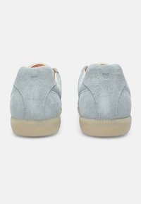 Light blue suede shoes with a low profile, rounded heels, and rubber soles. Minimalist design with no visible branding or embellishments.