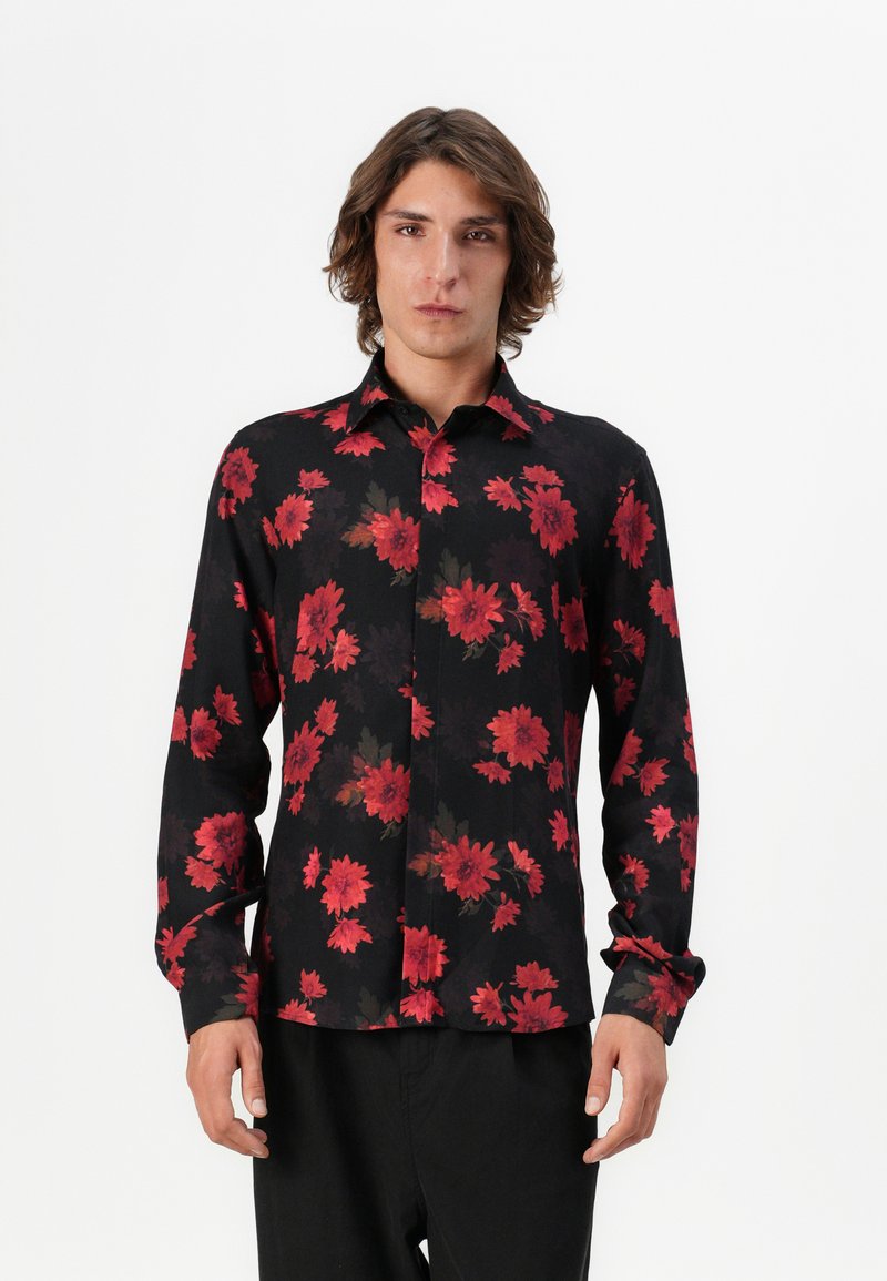 Sort skjorte med et dristigt rødt blomstermotiv, knap-op design, lange ærmer og klassisk krave. Blødt stof med let glans.