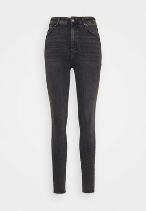 Jeans skinny em denim cinza escuro, com uma cintura alta, fecho de botão e bainha desfiada. Textura suave com um leve desvanecimento ao longo das pernas.