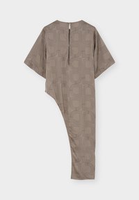 Robe marron asymétrique avec motif géométrique, manche courte côté gauche, manche longue côté droit, et encolure fendue dans le dos.