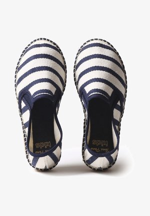 Scarpe slip-on in tela con strisce blu e bianche, tessuto texturizzato, bordi cuciti e pannelli laterali elastici per il comfort.