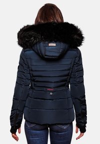 Granatowa kurtka puchowa z kapturem z sztucznym futrem, pionowym pikowaniem, dwoma bocznymi kieszeniami i metką marki przy szyi. Ściągacze na mankietach oraz dopasowany krój.