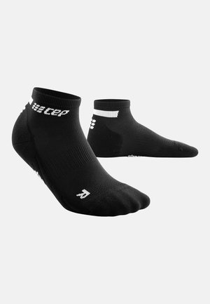 Schwarze Knöchelsocken mit strukturiertem Finish, featuring weißen Branding und einer ergonomischen Form für Komfort und Passform.