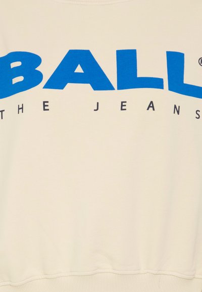 Sudadera de color crema con texto en negrita azul "BALL" y "THE JEANS". Textura suave con dobladillo y puños acanalados.