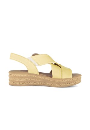 Sandale en cuir jaune avec des lanières croisées, une sangle arrière élastique de soutien et une semelle plateforme beige texturée.