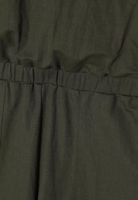 Tifon de culoare verde măsliniu cu o textură netedă, prevăzut cu un tiv elastic și pliseuri, creând o siluetă moale și relaxată.