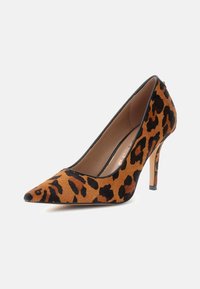 Pump con stampa leopardo in suede marrone e nero, con punta affusolata, sottile tacco a stiletto e bordi neri attorno all'apertura.