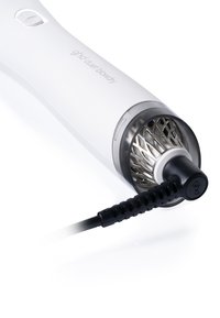Witte ghd duet föhn met zwarte stroomkabel en zichtbaar metalen verwarmingselement binnenin het ronde ventilatieopening.