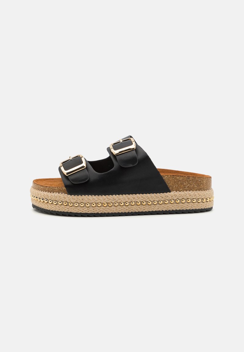Black slide sandals with double buckle straps, woven jute platform sole accented with gold beads, and cork footbed. Textured rubber outsole.