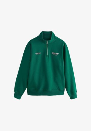 Green sweatshirt with a high collar, half zipper, and ribbed cuffs. Features embroidered text in white and pink on the chest. Soft fabric texture.