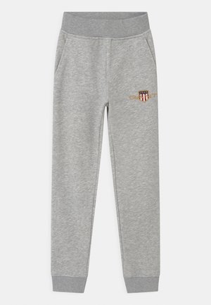 Pantalon de survêtement gris avec une texture douce, doté de poches latérales, d'une taille élastique et d'un petit logo brodé sur une cuisse.