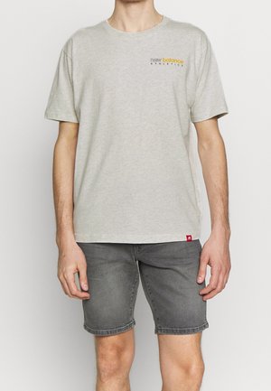 Grijze katoenen t-shirt met korte mouwen, voorzien van de tekst "new balance ATHLETICS" in geel en zwart, met een klein rood label op de zoom.