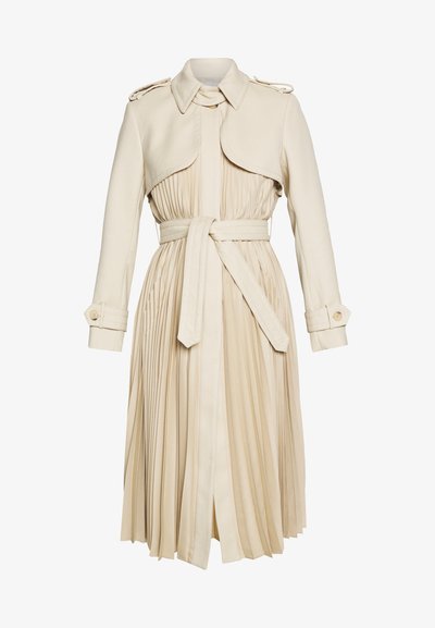 Beež trench coat, millel on volditud seelik, vöödiga talje ja krae. Omab õlavarre epaulette ja nööbiga mansette. Sile kangast tekstuur.