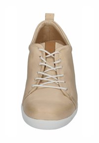 Beige leather sneaker with white laces, textured front and a rubber sole. Features a minimalistic design and a small heel tab at the back.