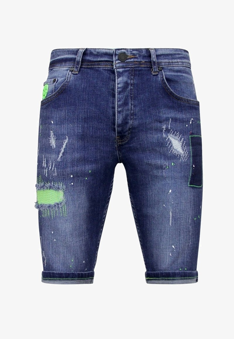 Donkerblauwe denimshorts met versleten details en groene accenten. Kenmerken zijn onder andere zakken, een knoopsluiting en rafelige hemden met verfspetters.