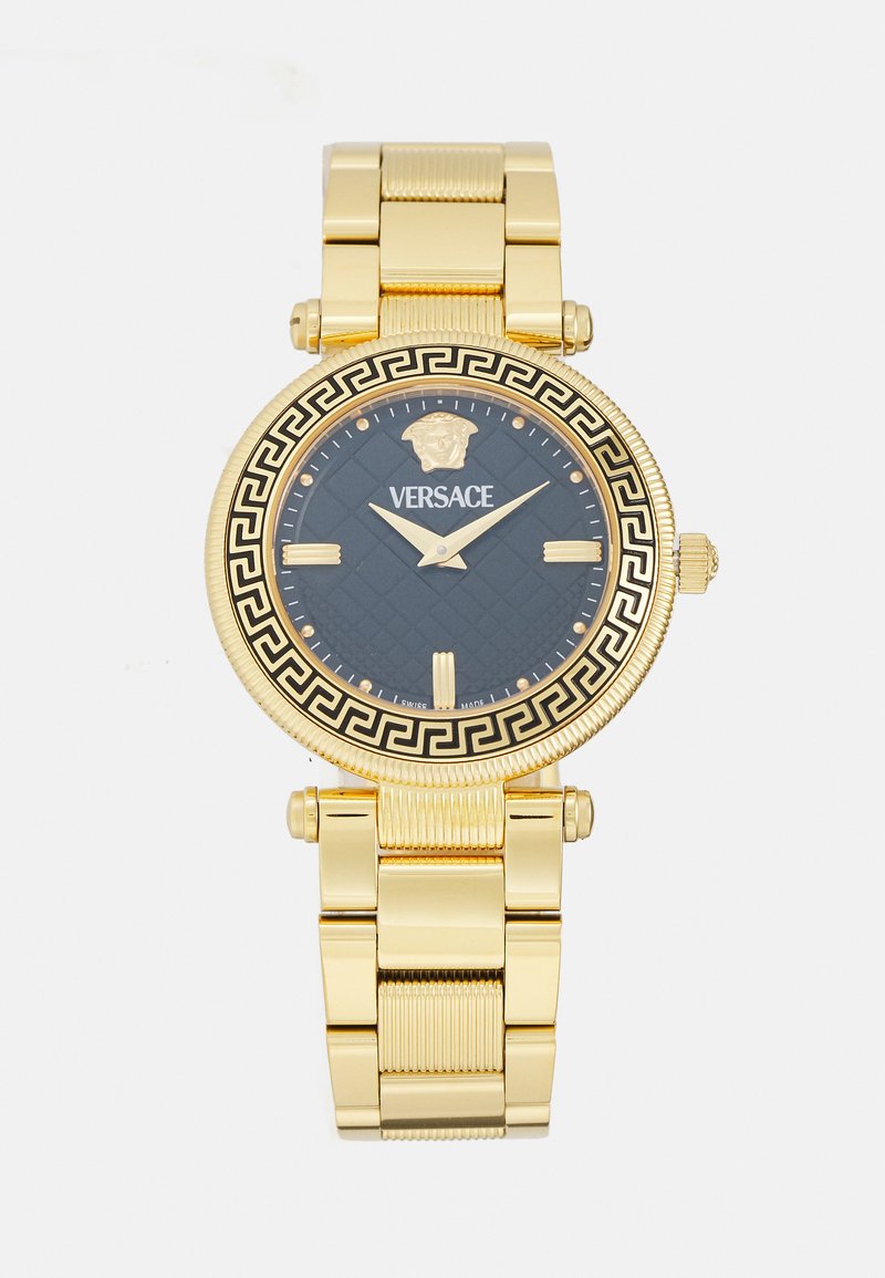Auksinės spalvos Versace laikrodis su juodu ciferblatu, sudėtingu raštuotu paviršiumi, Medūzos simboliu ir graikiškais raktų motyvais ant korpuso. Metalinės grandinėlės.