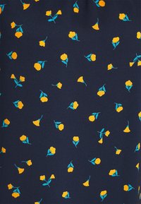 Dunkelblauer Stoff mit verstreuten kleinen gelben Blumen und grünen Blättern, die ein zartes florales Muster bilden.