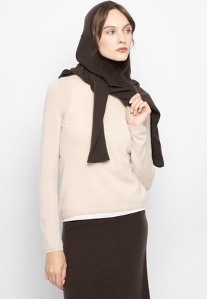 Beige long-sleeve sweater with a brown scarf draped over the shoulders, worn with a matching brown skirt. Soft, textured fabric.