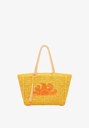 Borsa a tracolla gialla intrecciata con manici intrecciati e ricami floreali arancioni. Presenta un dettaglio con una frangia e la parola "SUNDEK" sul davanti.