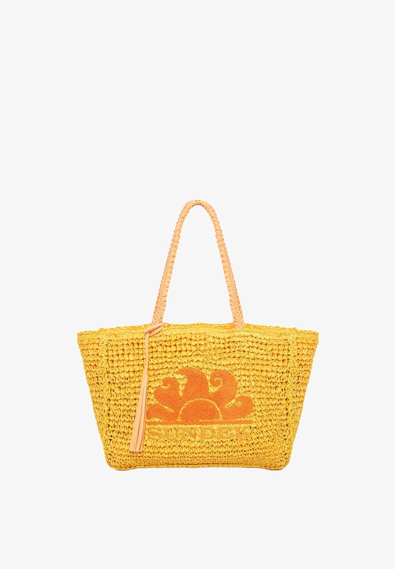 Borsa a tracolla gialla intrecciata con manici intrecciati e ricami floreali arancioni. Presenta un dettaglio con una frangia e la parola "SUNDEK" sul davanti.