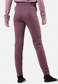 Violetti tilavat leggingit, joissa on istuva muotoilu ja joustava vyötärö, jossa on brändin nimi, yhdistettynä mustiin sukkiin.