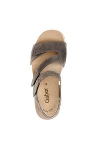Sandalo in suede grigio con tre cinghie ondulate. Soletta beige morbida contrassegnata "Gabor" e "Best Fitting". Suola piatta con texture minima.