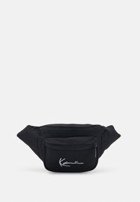 Mustaväriinen vyölaukku, jossa on kaksi vetoketjullista taskua, hopeinen brodeerattu logo, pehmeä tekstuuri ja tyylikäs, kompakti muotoilu.