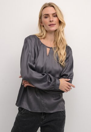 Gray satin blouse with a round neckline, front keyhole detail, and long, gathered sleeves. Smooth texture and loose fit.