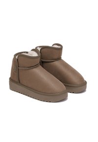 Botas tobilleras marrones hechas de material suave con un forro de piel de borrego, punta redonda y suela de goma plana con un patrón de textura en la banda de rodadura.