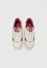 Άσπρα και βουργουνδί αθλητικά παπούτσια με υφές από δίχτυ και καστόρι, με στρογγυλό λογότυπο, κορδόνια και λαστιχένιες σόλες. Άποψη από πάνω προς τα κάτω.