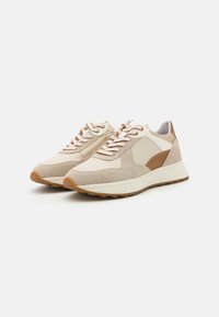Beige Sneaker aus einer Mischung aus Wildleder und Leder, mit weißen Mesh-Einsätzen, braunen Akzenten und strukturierten Gummisohlen. Flache Schnürsenkel in Beige.