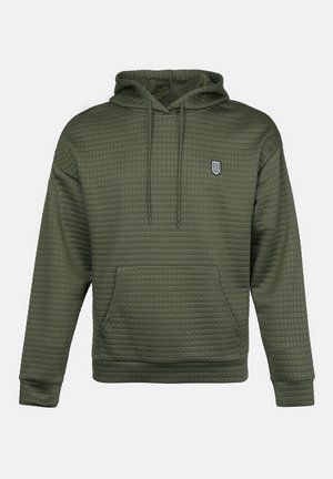 Felpa verde oliva con texture trapuntata, tasca centrale a marsupio e un piccolo logo ricamato sul petto. Cappuccio regolabile con cordini.