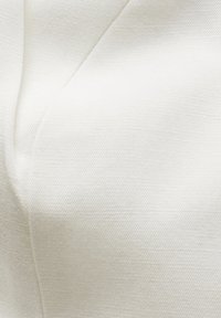 Witte stof van dichtbij, gladde textuur met subtiele glans. Bevat een gestikte naad, minimalistisch ontwerp en geen zichtbare patronen.